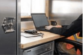 Person working on a laptop at a desk with a coffee cup nearby.
